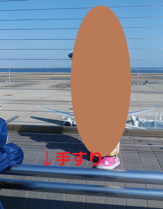 羽田空港第二ターミナル5階の南東側展望デッキの手すりの向こう側へ立つ管理人の息子
